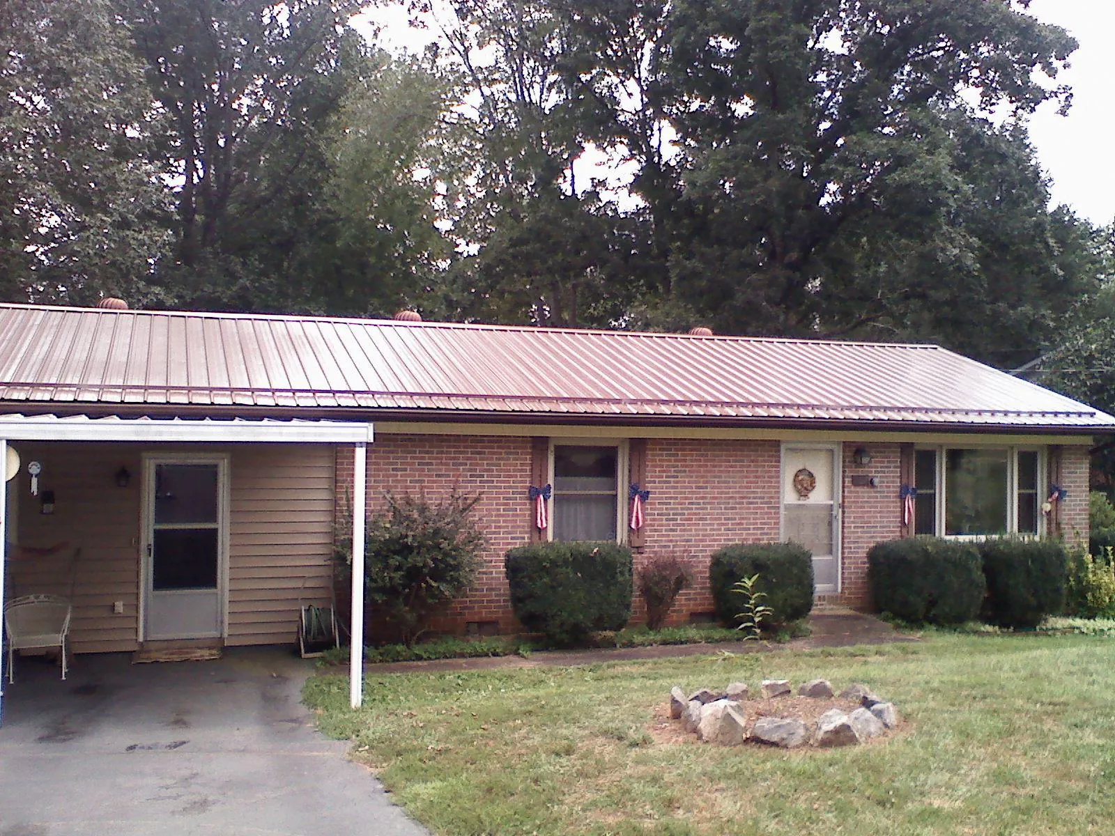 Bronze metal roof and carport on a brick ranch home — Roof Repair work by our crew in Laura