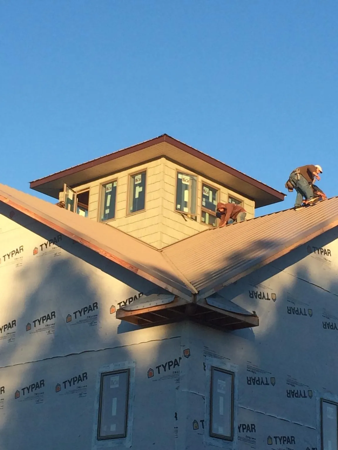 Roofers working around a rooftop cupola on a new metal roof at sunset — Roof Waterproofing in Laura by Roofing Brothers